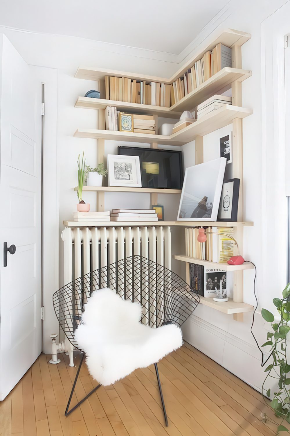 A cozy reading nook with a comfy chair and bookshelves over the radiator is a warm and cozy space.