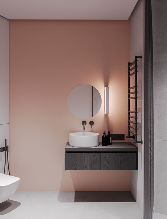 A pink painted statement wall to add a splash of color to a minimalist bathroom.