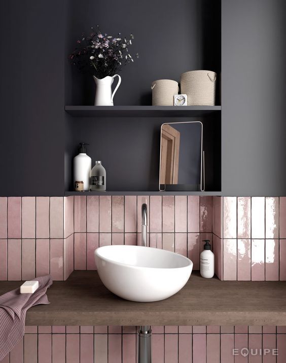 A combo of glossy pink long narrow tiles and a matte black cabinet over them for a chic modern look.