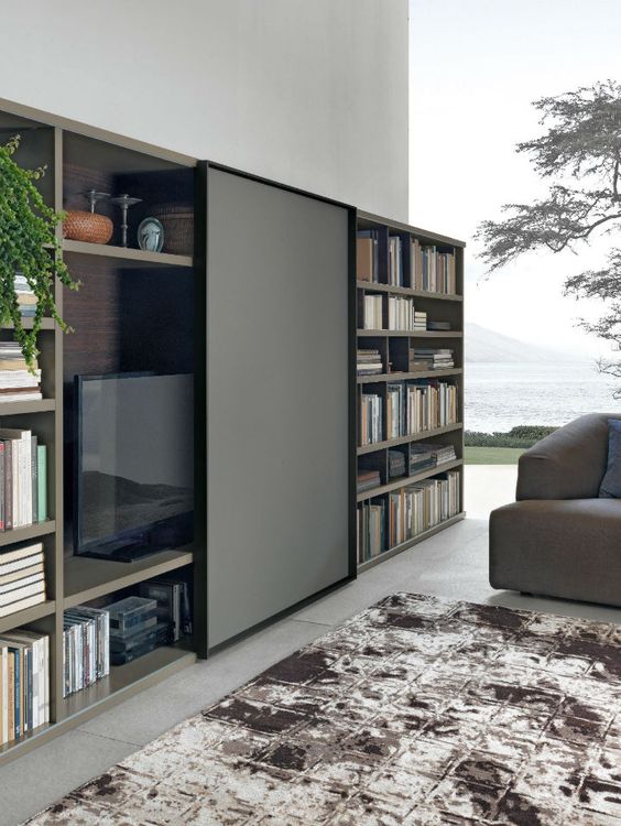 A bookcase with a sliding panel that can hide your TV easily and with style is a cool idea for a modern space.