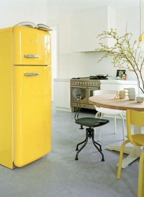 Cheer up a neutral and peaceful kitchen with a sunny yellow Smeg fridge and a matching chair.