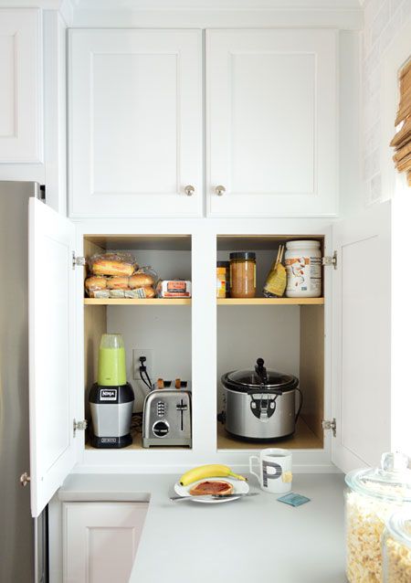 A kitchen cabinet with small appliances and with usual doors to take and put back everything you have.