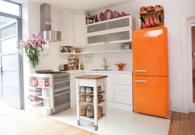 A neutral modern kitchen with a bold orange Smeg fridge for a colorful statement.
