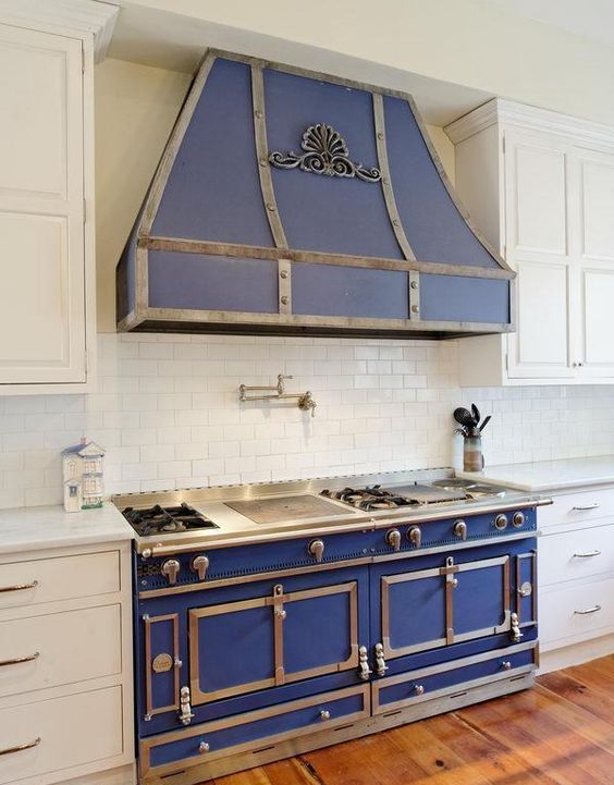 A beautiful retro blue kitchen stove with a hood and stainless steel fittings.