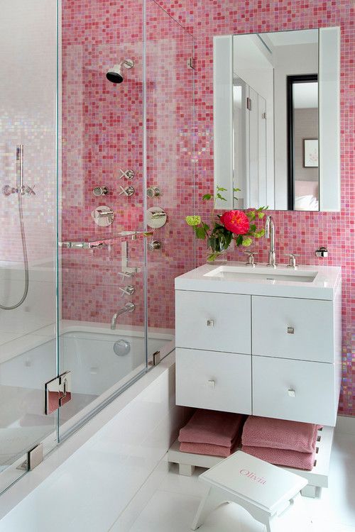 Pink mosaic tiles on the walls and matching towels paired with white details for a contrasting look.