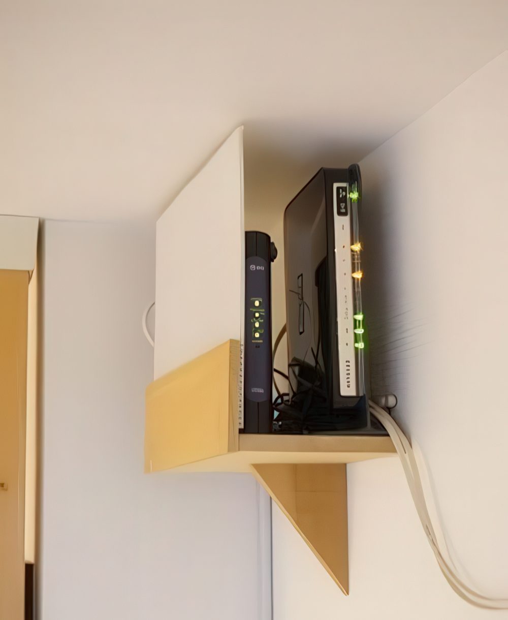 A mini shelf attached right under the ceiling will elegantly hide your router and will merge with the color of the walls and ceiling.