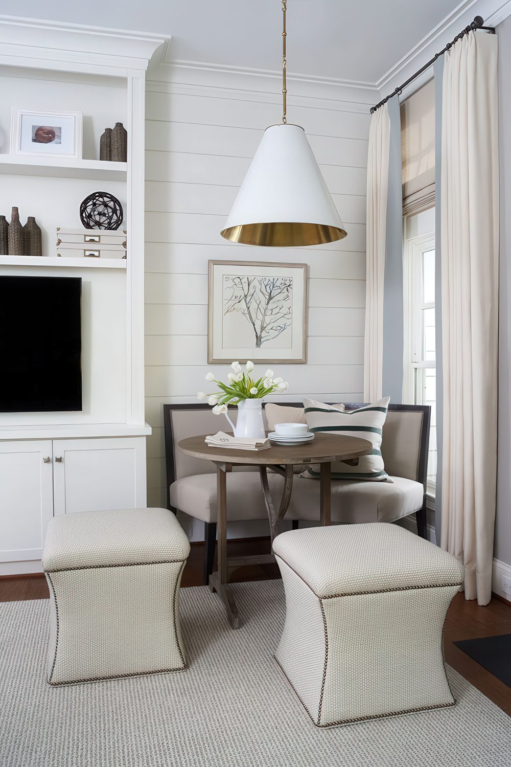 A quiet corner with a small breakfast area, a curved sofa and upholstered poufs, a lamp to highlight the space.