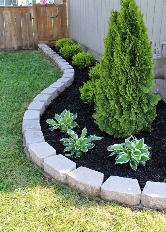 Simple brick garden edging to highlight the raised garden bed and separate it from the lawn.