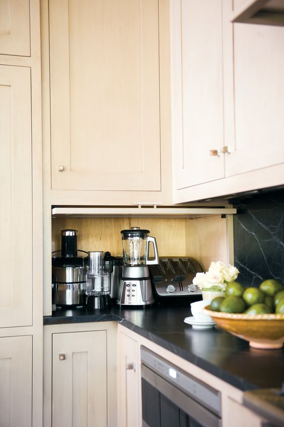 All the kitchen appliances placed inside a small cabinet with a garage-style door for fast access anytime.