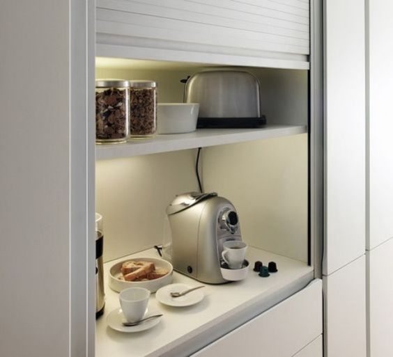 An open storage compartment finished with blinds is an ideal space for appliances and lights and sockets inside let you use them at once.