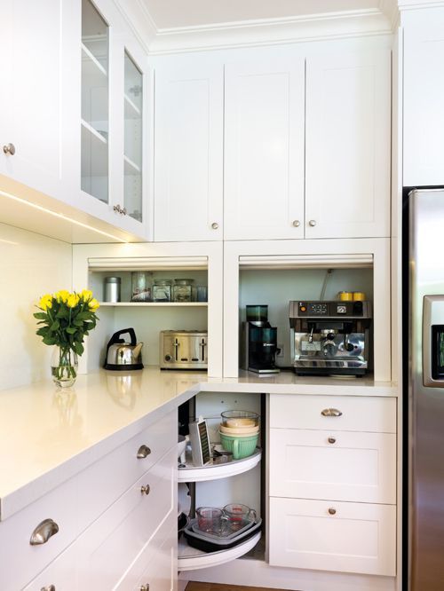 Kitchen appliances hidden in comfortable countertop cabinets, with doors to raise is a stylish idea.