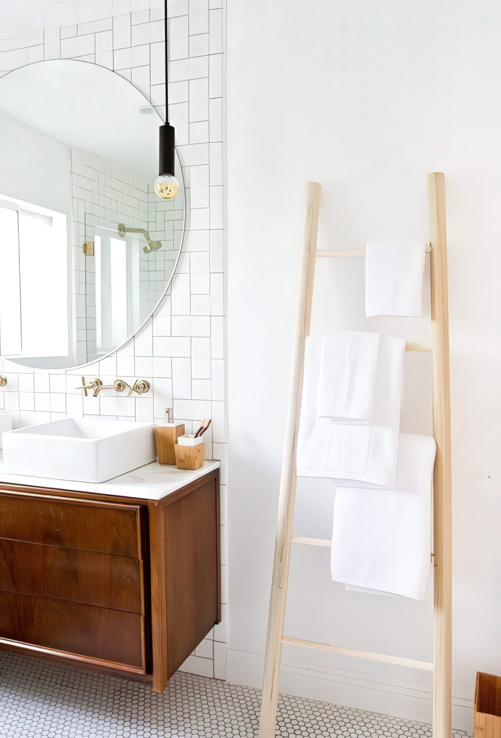 A simple wooden ladder with some towels is a cool space-saving towel storage idea for every kind of bathroom.