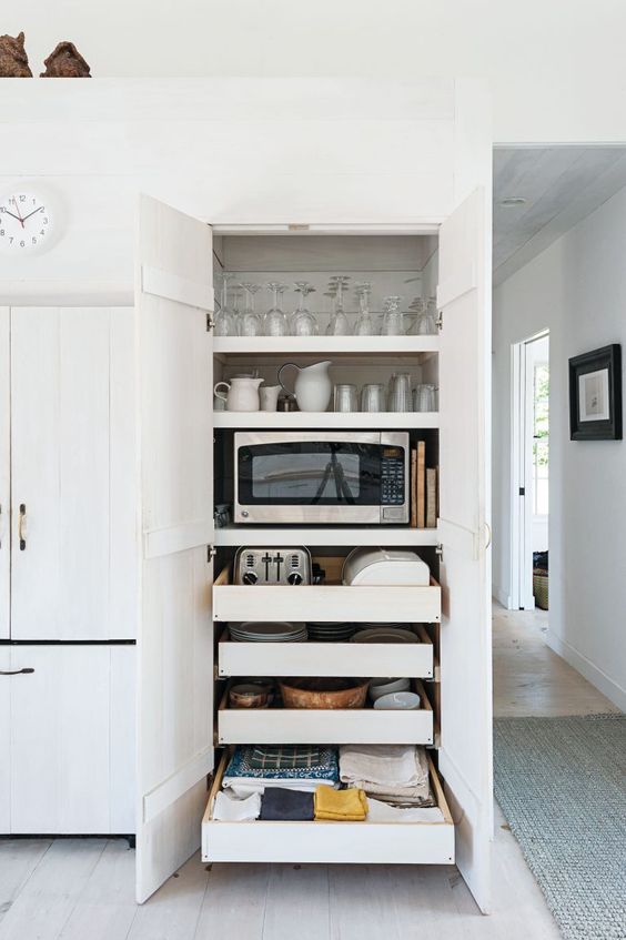 Slide put pantry kitchen drawers holding appliances, tableware, glasses and other stuff is a great idea for a modern kitchen.