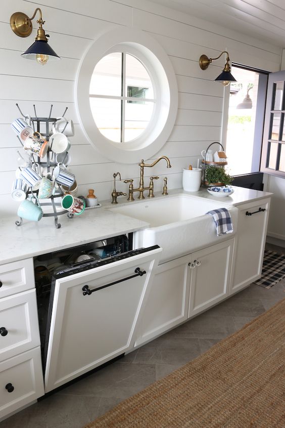 A dishwasher hidden in a cabinet to perfectly match the vintage farmhouse design of the kitchen and not to add a modern touch to its chic look.