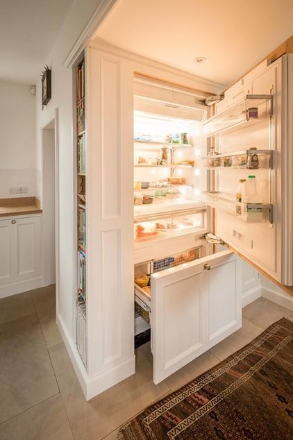 A fridge hidden inside kitchen cabinets and with additional side shelves for more effective storage.