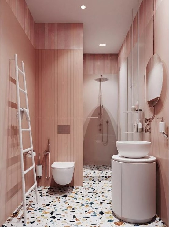 A delicate blush bathroom with a bright terrazzo floor and white furniture and appliances to refresh the space.