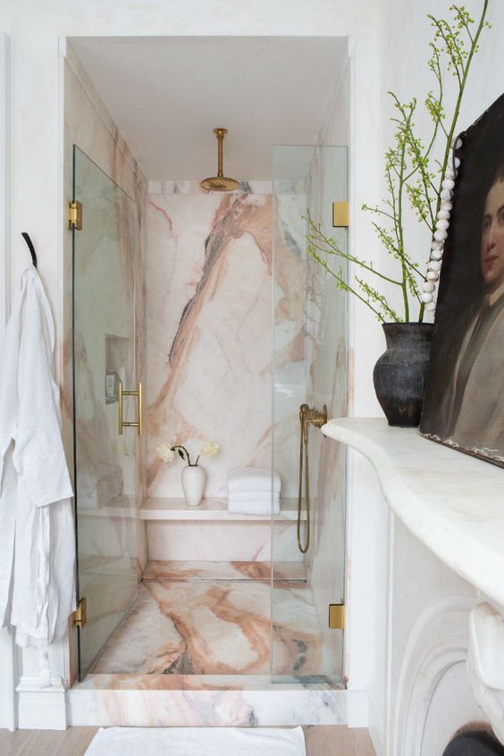 A gorgeous pink marble shower space wiht glass doors and elegant copper fixtures is a lovely idea that looks super refined.