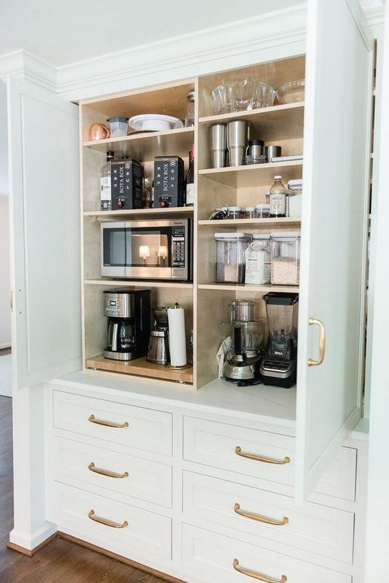 A large cabinet with all kinds of appliances, some bowls and jars is a cool idea to store what you don't need and hide it.