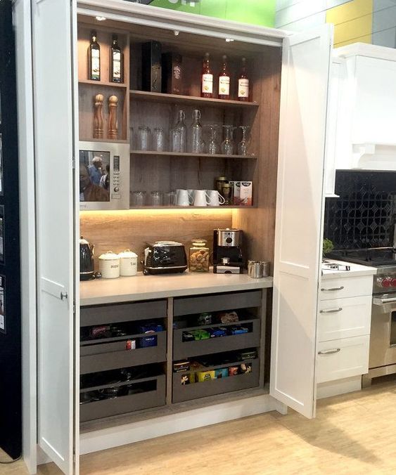 A large storage unit with open shelves and drawers, appliances, mugs, glasses, wine and other stuff is a good space for cooking here.