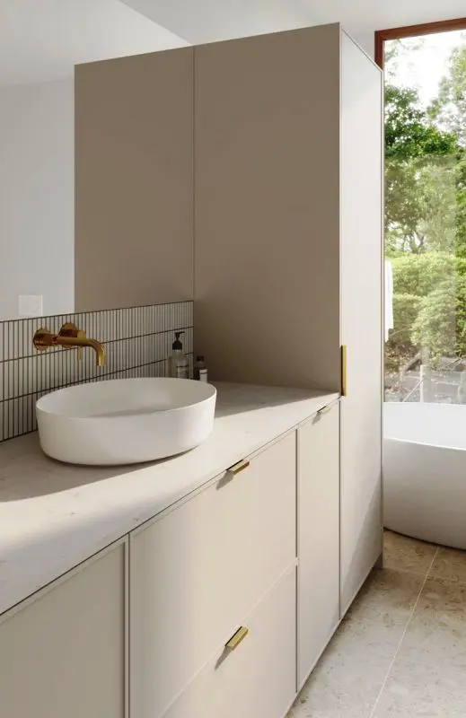 A minimalist bathroom with greige storage units including IKEA Metod, a bathtub and a skinny tile backsplash.