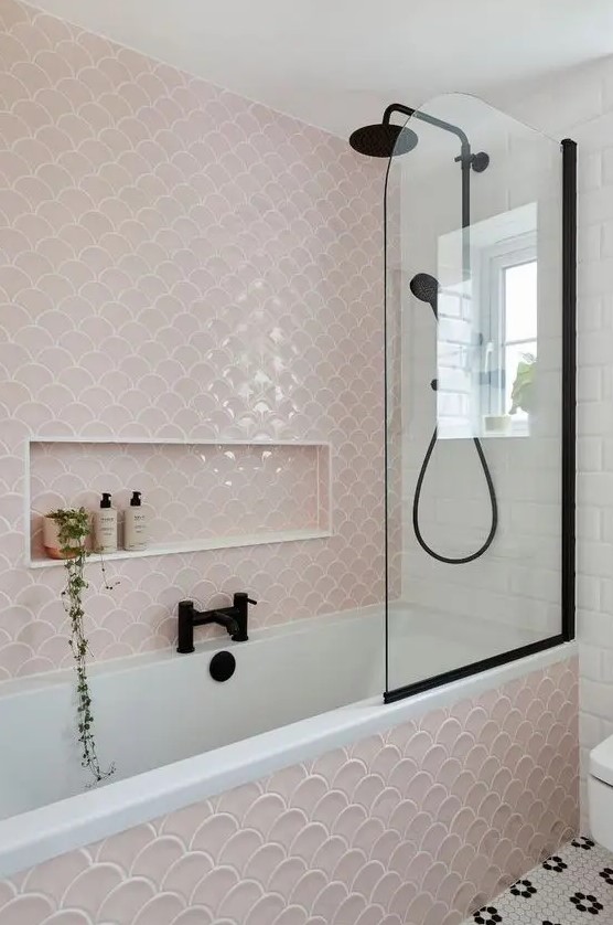 Blush and black tones create a striking contrast in this modern bathroom with fishscale tiles. Penny tiles on the floor and black fixtures add sophistication. Opt for bold color combinations and unique tile designs for a contemporary bathroom.