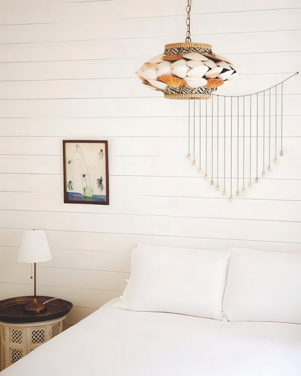 A pendant lamp of seashells and jute is a catchy and bold idea for a coastal space.
