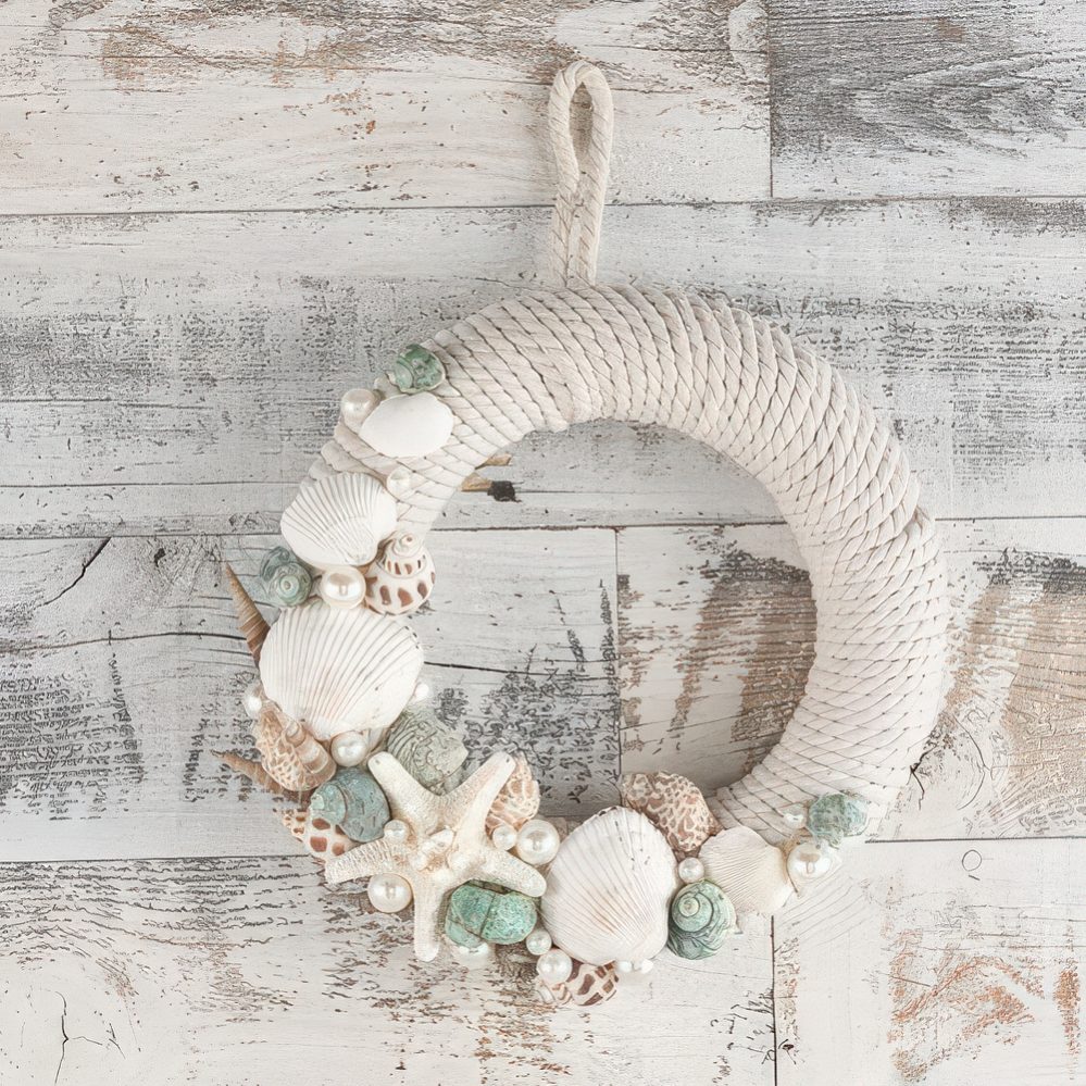 A pretty rope wreath with starfish, seashells and various pearls looks very coastal or beachy.