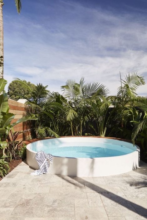 A raised round pool surrounded with tropical plants is a stylish and minimal option to go for.