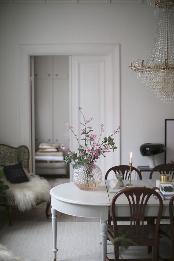A refined patterned glass vase with pink flowers and a matching crystal chandelier for an exquisite feel.