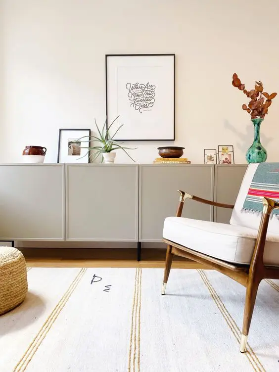 A stylish Scandinavian credenza in dove grey made of IKEA Metod cabinets, with lovely decor and plants.