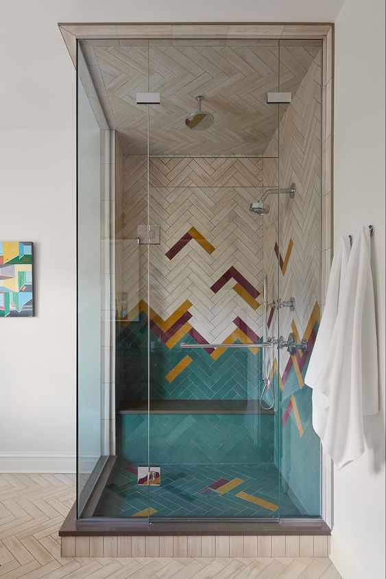 A super creative colorful shower space done with green, burgundy, mustard chevron tiles and enclosed in glass is amazing.