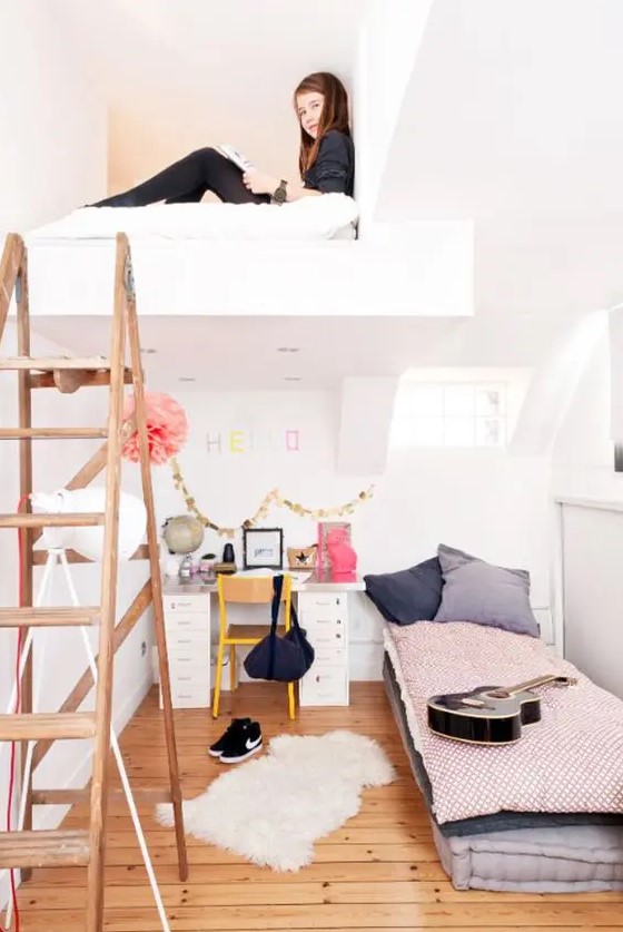 A two level girl's bedroom with a loft bedroom and a bed and a desk on the lower level plus a staircase.