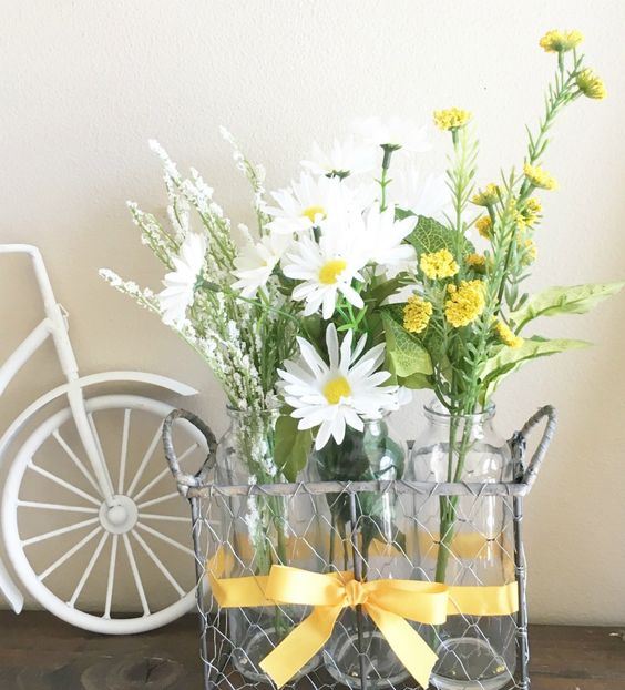 A wire basket with bottles and white and yellow blooms is a chic and simple rustic decoration.