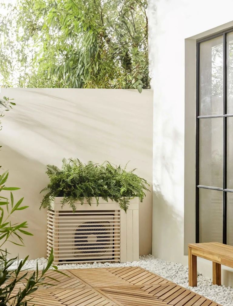 This simple and modern AC unit cover features a tray with greenery on top, and it matches the outdoor space.