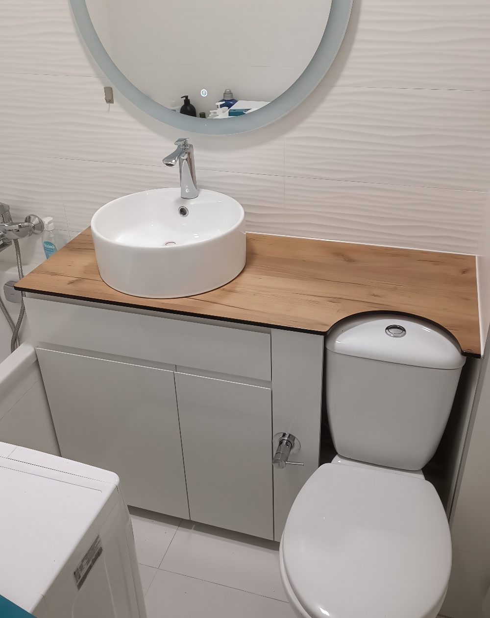 Designed for functionality, this bathroom features a smart combination of a countertop sink and a concealed storage cabinet under a wooden surface. It's an efficient yet stylish solution for small apartment bathrooms.

(@makemebel.by).