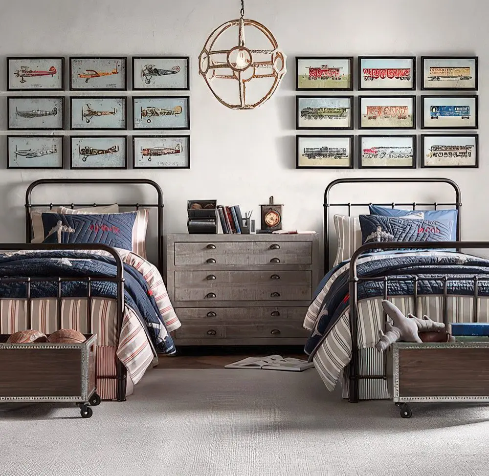 A rugged, industrial-inspired twin bedroom with metal-framed beds, airplane blueprint wall art, and rustic furniture. The neutral palette and antique accents evoke a vintage pilot’s aesthetic.