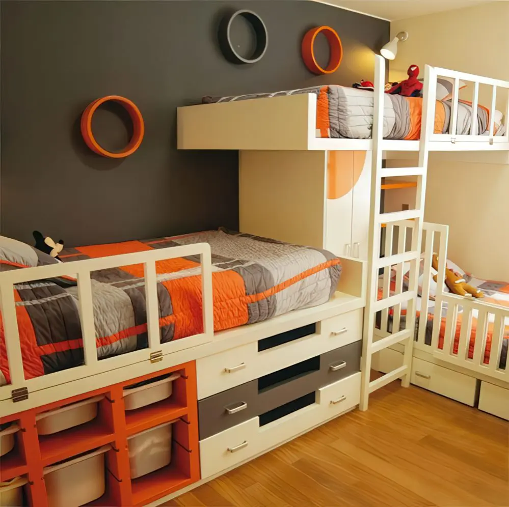 A functional triple bunk bed setup with built-in storage drawers and orange and gray bedding. The playful circular wall décor and integrated shelving add both fun and practicality.