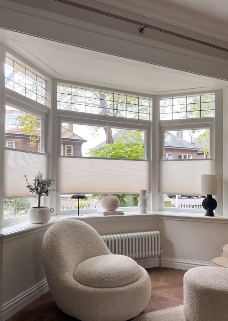 The bow window is done with shades covering only the central part of it, so that more privacy and less view were present.