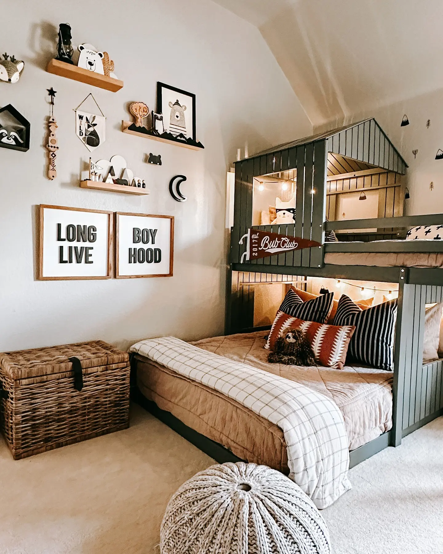 A charming space with a house-shaped bunk bed structure. Earth-toned bedding, woven baskets, and soft lighting create a warm and playful retreat for kids.

(@courtneyfitzp01).