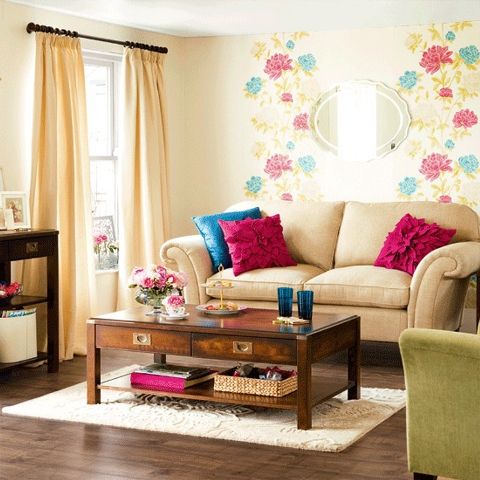 A bright floral wall, colorful furniture and pillows bring a strong summer feel to the space.