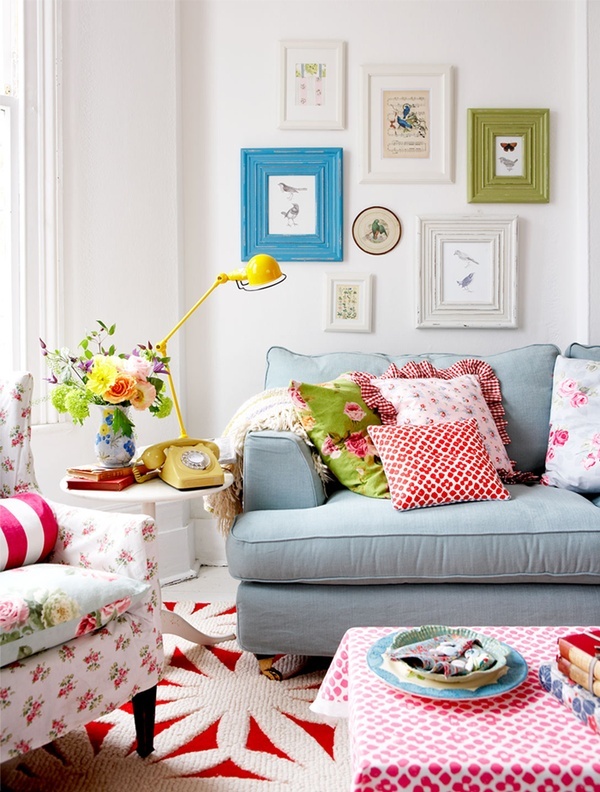 Bright printed floral pillows and furniture, a bold gallery wall and rugs for a fun and bold summer living room.