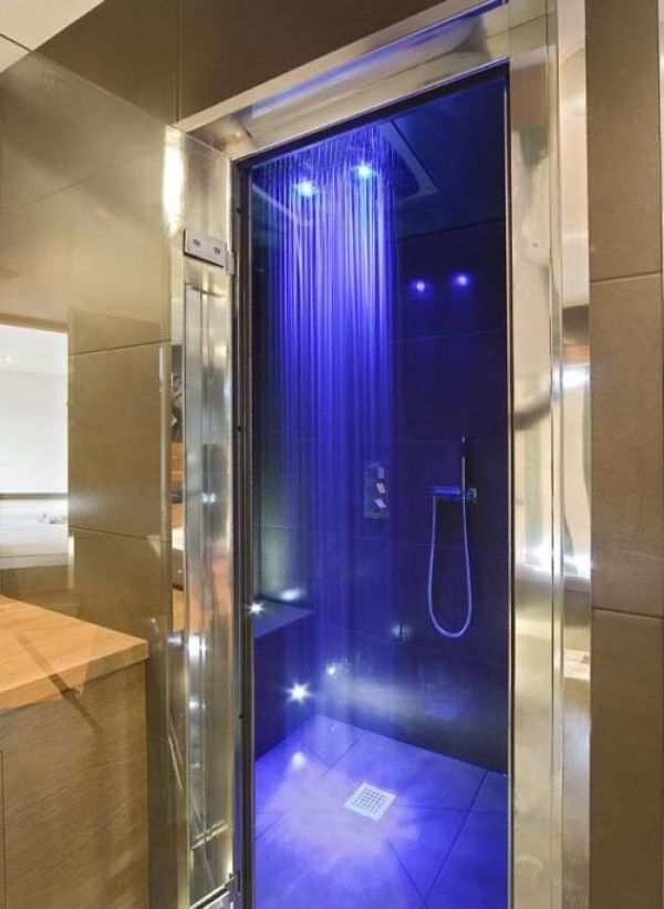 An elegant and shiny shower space with purple lights inside and rain shower is a great space to get relaxed thanks to the colors and rain shower.