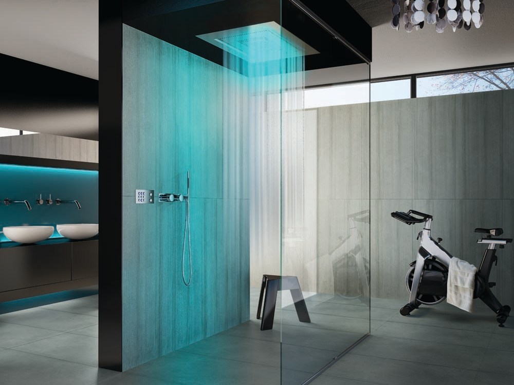 A contemporary bathroom with glass walls and a single stone clad one, with colored lights and a rain shower is a lovely and ultra-modern idea.