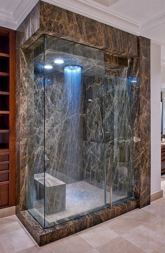 A sophisticated marble shower space with blue lights and a rain shower is a great idea for a chic and elegant bathroom.