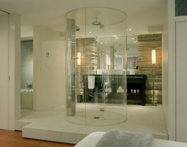 A neutral contemporary bedroom with a bathroom integrated here, with a clear glass round shower is a lovely idea.