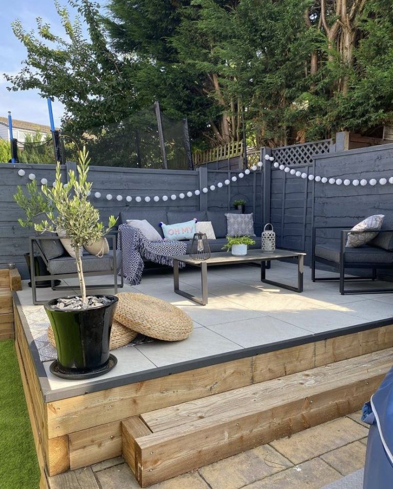 Style a corner of your garden with a raised deck, this one is clad with tile for durability and is styled with elegant modern furniture.