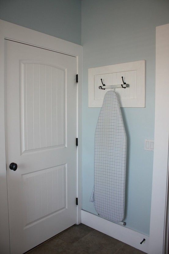 A rack with hooks can be used for hanging an iron board, it won't take any floor space.