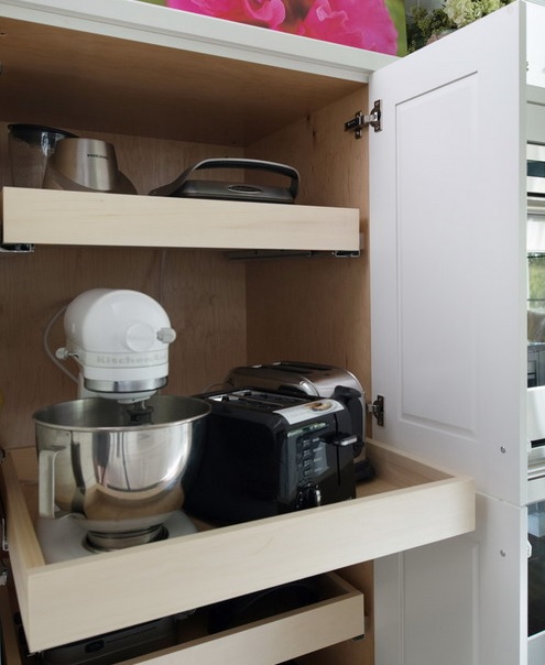 A cabinet with several retracting shelves that hold various applainces and is amazing for every kitchen to keep the clutter away.