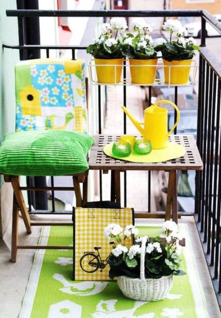 A bright and colorful summer balcony with bold green textiles, potted blooms and colorful tableware for a vivacious feel.