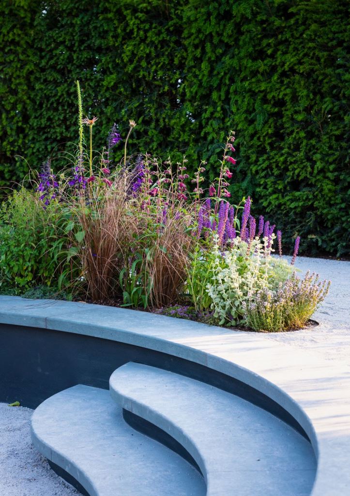 This curved contemporary deck includes a planter and matching curved steps that instantly give an ultimate feel to the space.
